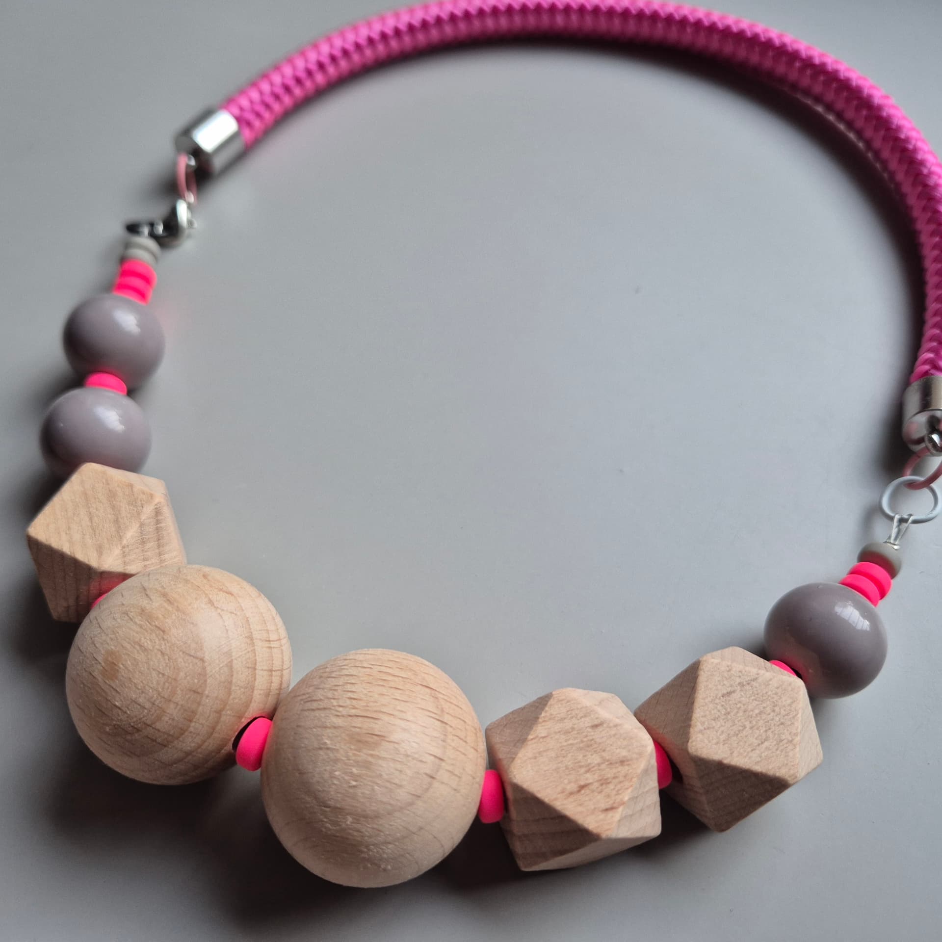 Necklace of natural beech spheres and facets with neon pink discs on a hot pink rope