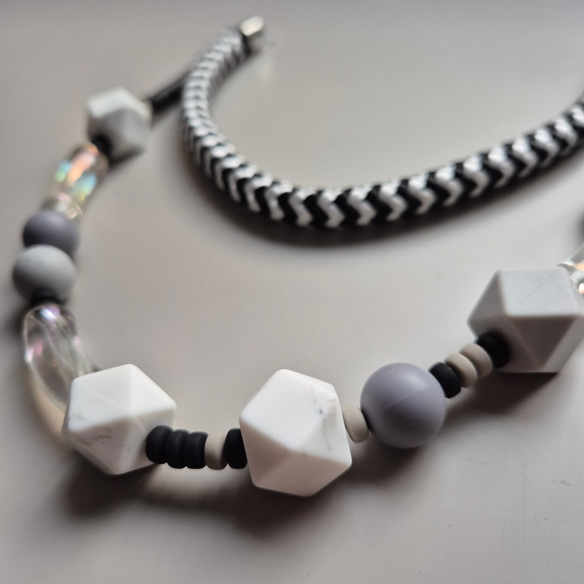 Monochrome necklace with white marbled faceted beads, grey spheres and clear glass on chevron rope